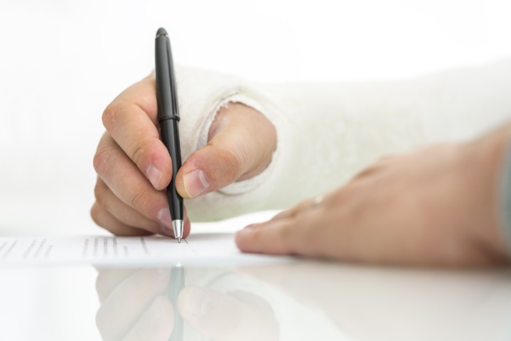 An injured person filling out paperwork